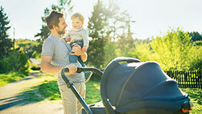 Ein Vater mit seinem Kind und Kinderwagen.