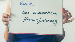 Kathrin Demmler hält Zeichenblock mit handschriftlichem Statement hoch.