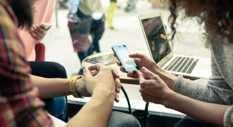  Szene: Zwei Menschen schauen auf ein Smartphone.