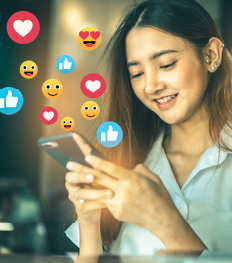Eine Jugendliche beim Chatten. Aus ihrem Smartphone steigen Emojs auf.